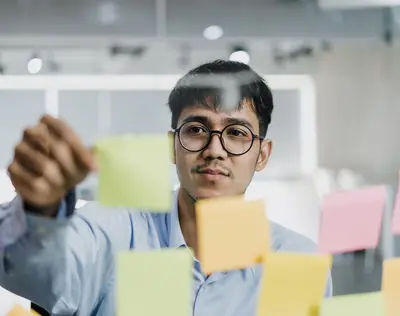 شاب يرتب ملاحظات ملونة